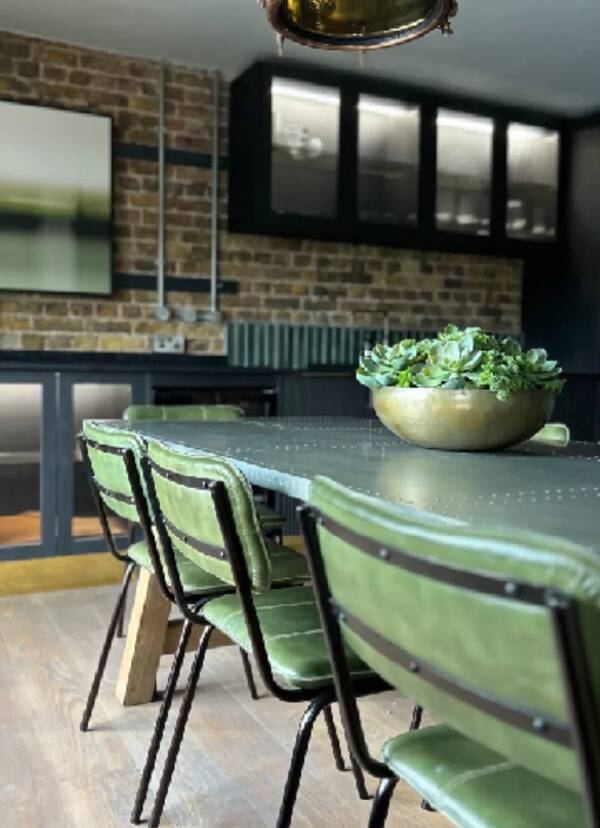 green leather chairs in industrial style dining room